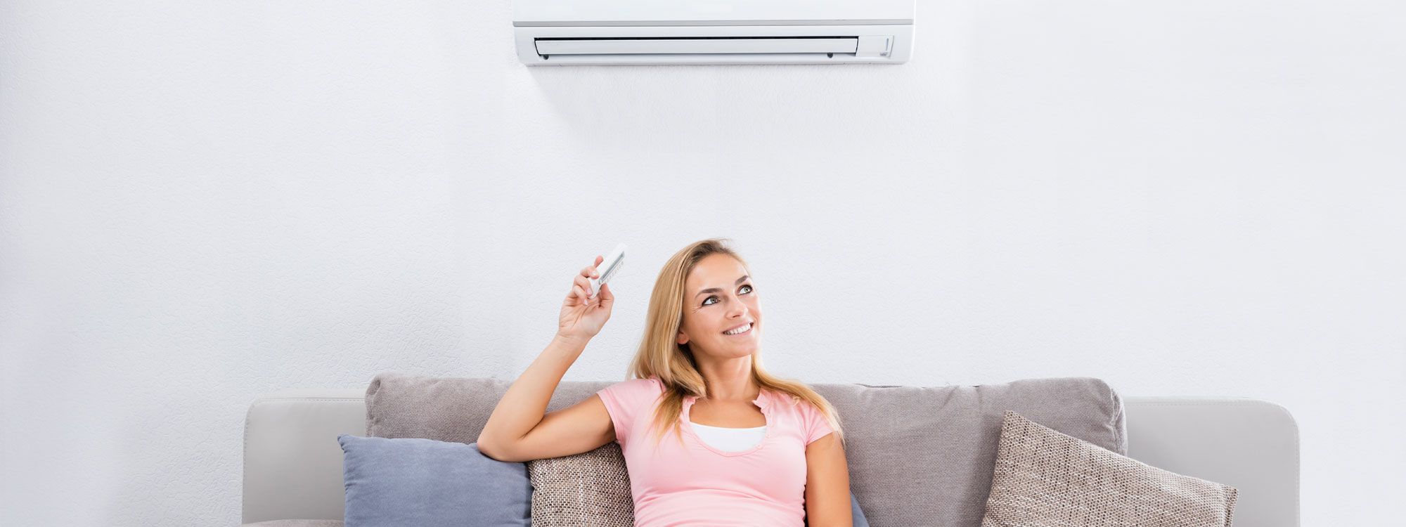 Lady using air conditioning unit in her home in Chester